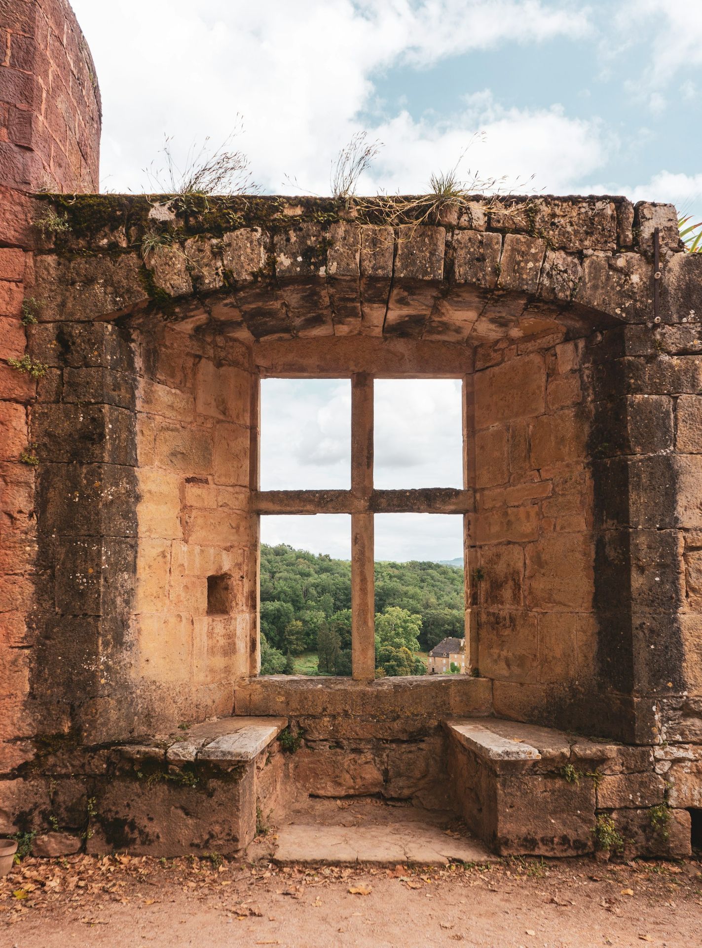 a window in a stone building with a bench in front of it